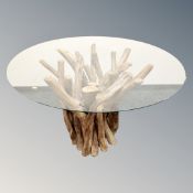 A contemporary Barker & Stonehouse Whinfell circular glass topped dining table on a root wood base,