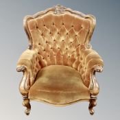 A Victorian style carved beech armchair in golden buttoned fabric