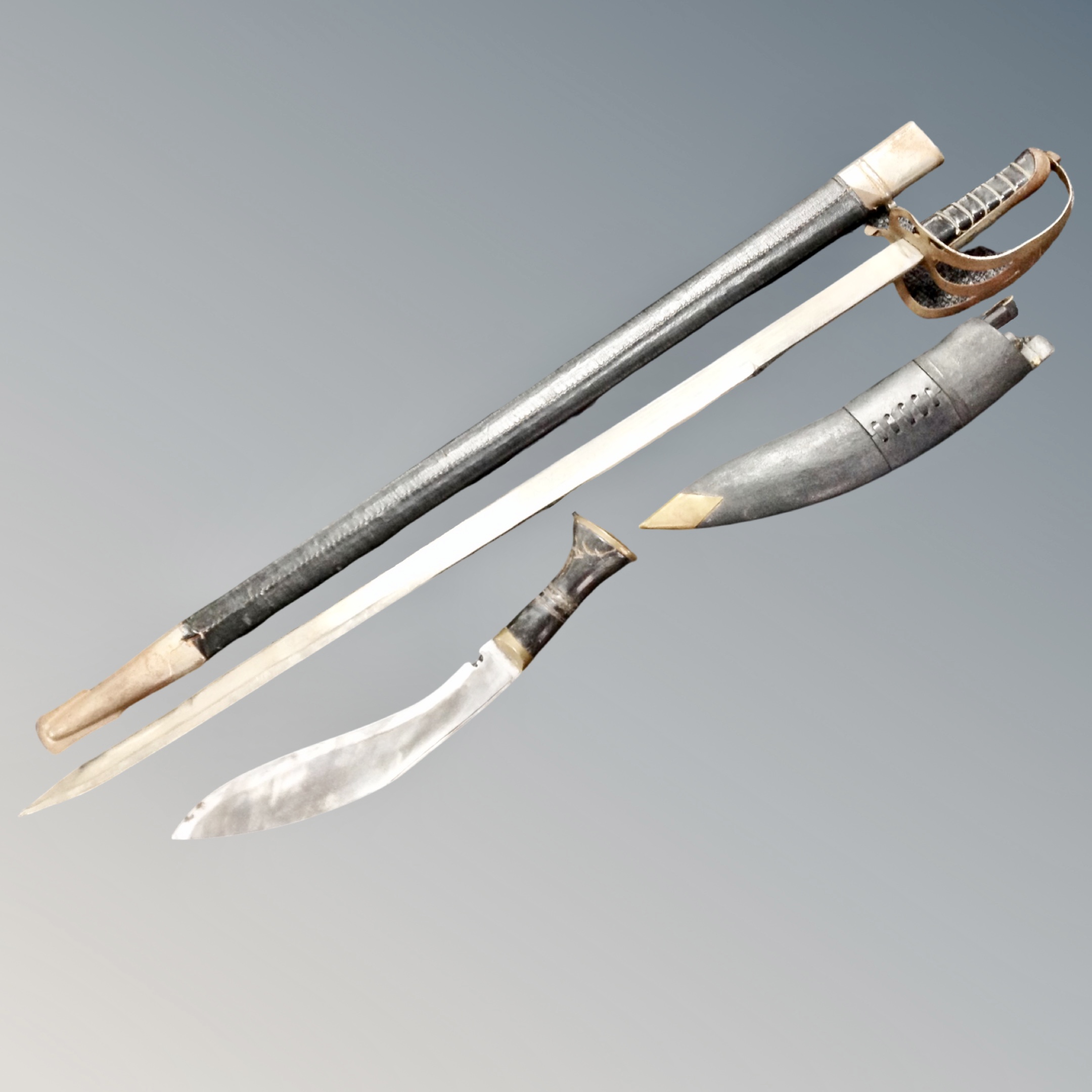 An Indian sword in sheath together with a Kukri knife in sheath