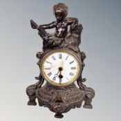 A Victorian cast iron mantel clock surmounted with a cherub