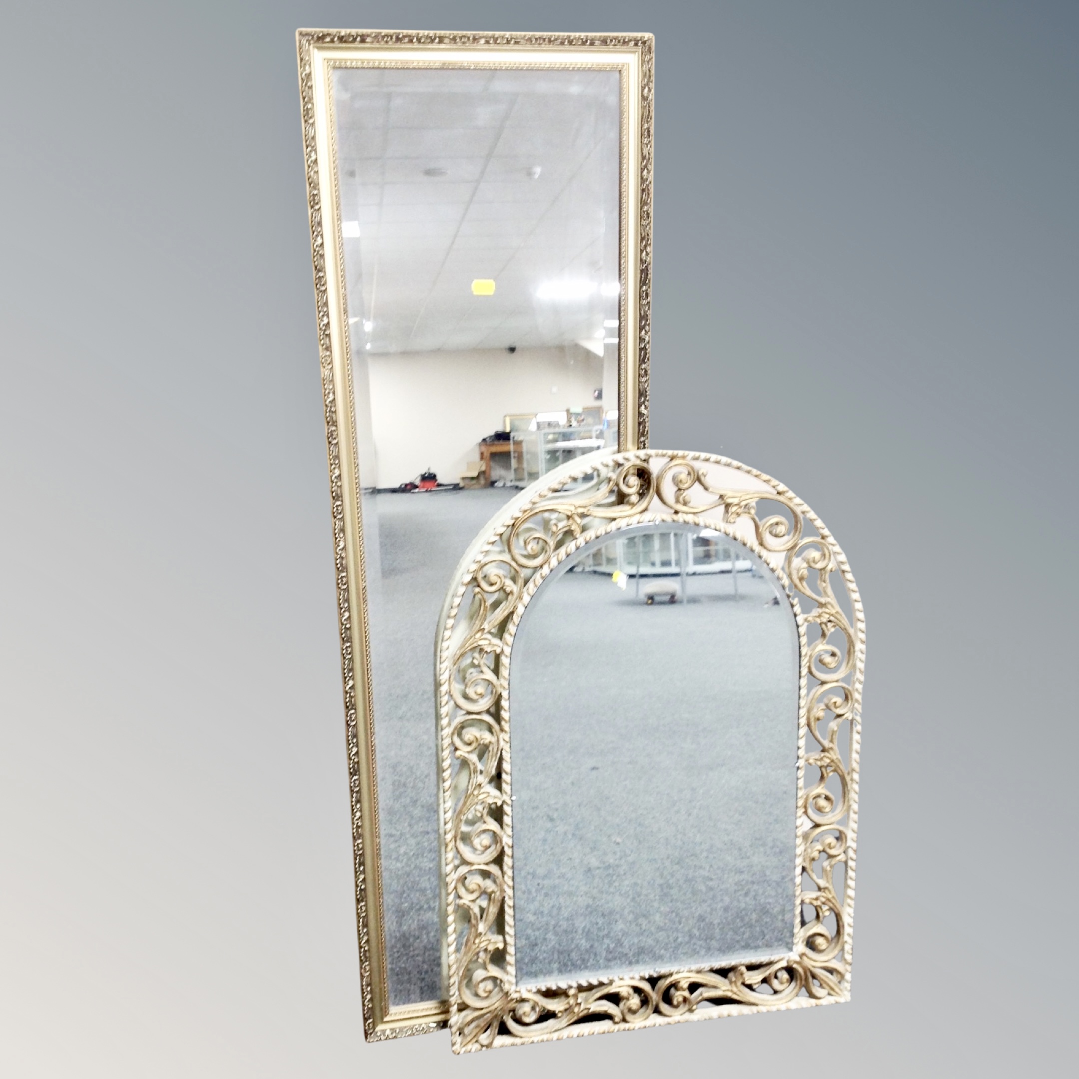 A cream and gilt decorative arch topped bevelled mirror together with gilt framed hall mirror