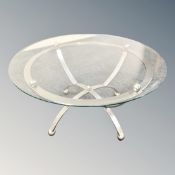 A contemporary circular glass topped coffee table on metal base together with further metal throne