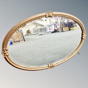 An antique gilt framed beaded oval mirror