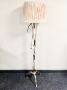 A brass and porcelain standard lamp with shade