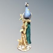 A continental ceramic figure - Peacock on branch,