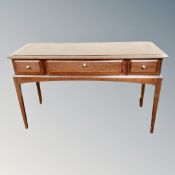 A Stag Minstrel three drawer dressing table on raised legs