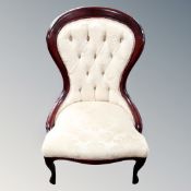 A Victorian style nursing chair in cream buttoned fabric