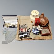 A wicker tray containing miniature brass crosses, boxwood ruler, metal sundial, assorted coins,
