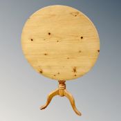 A circular pine tilt topped occasional table