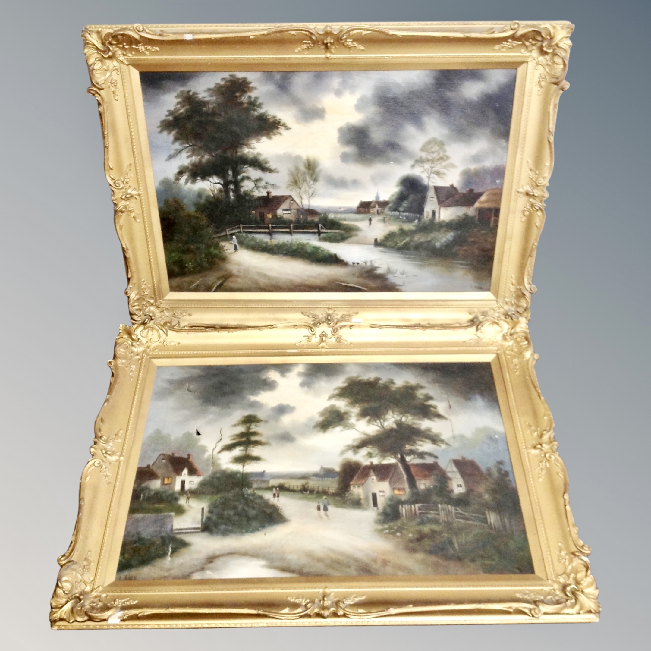 A pair of R Keen antique oils on canvas depicting figures in a rural village in gilt frames
