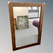A mirror in oak frame with brass corner fixtures,