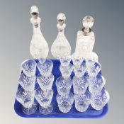 A tray of assorted crystal glasses and three crystal decanters