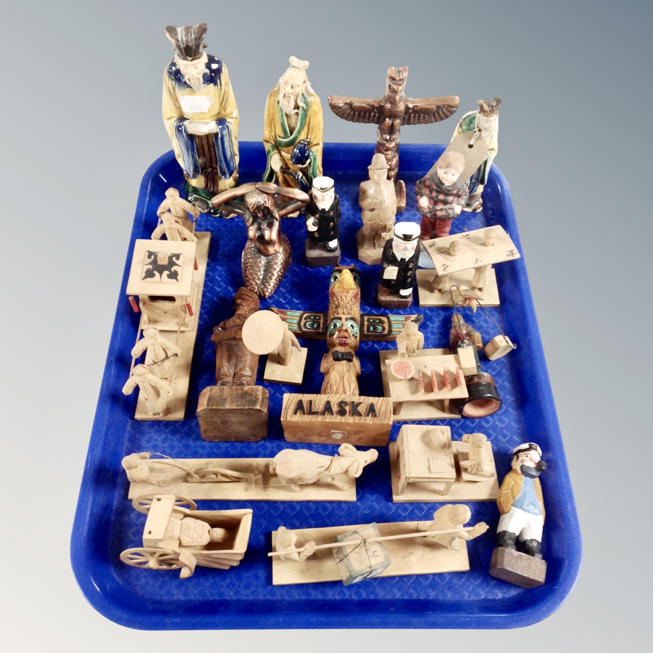 A tray of wooden and ceramic tourist carvings and figures