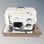 A Singer electric sewing machine with pedal in case