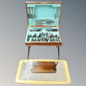 A 1970's cutlery canteen on stand together with a frameless mirror on board