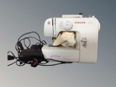 A Singer Start electric sewing machine with two foot pedals and cover