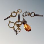 Four pocket watch keys together with an earring.