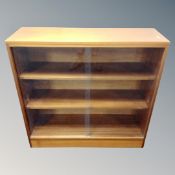 A teak sliding door glazed bookcase, width 90 cm, height 87 cm, depth 29.