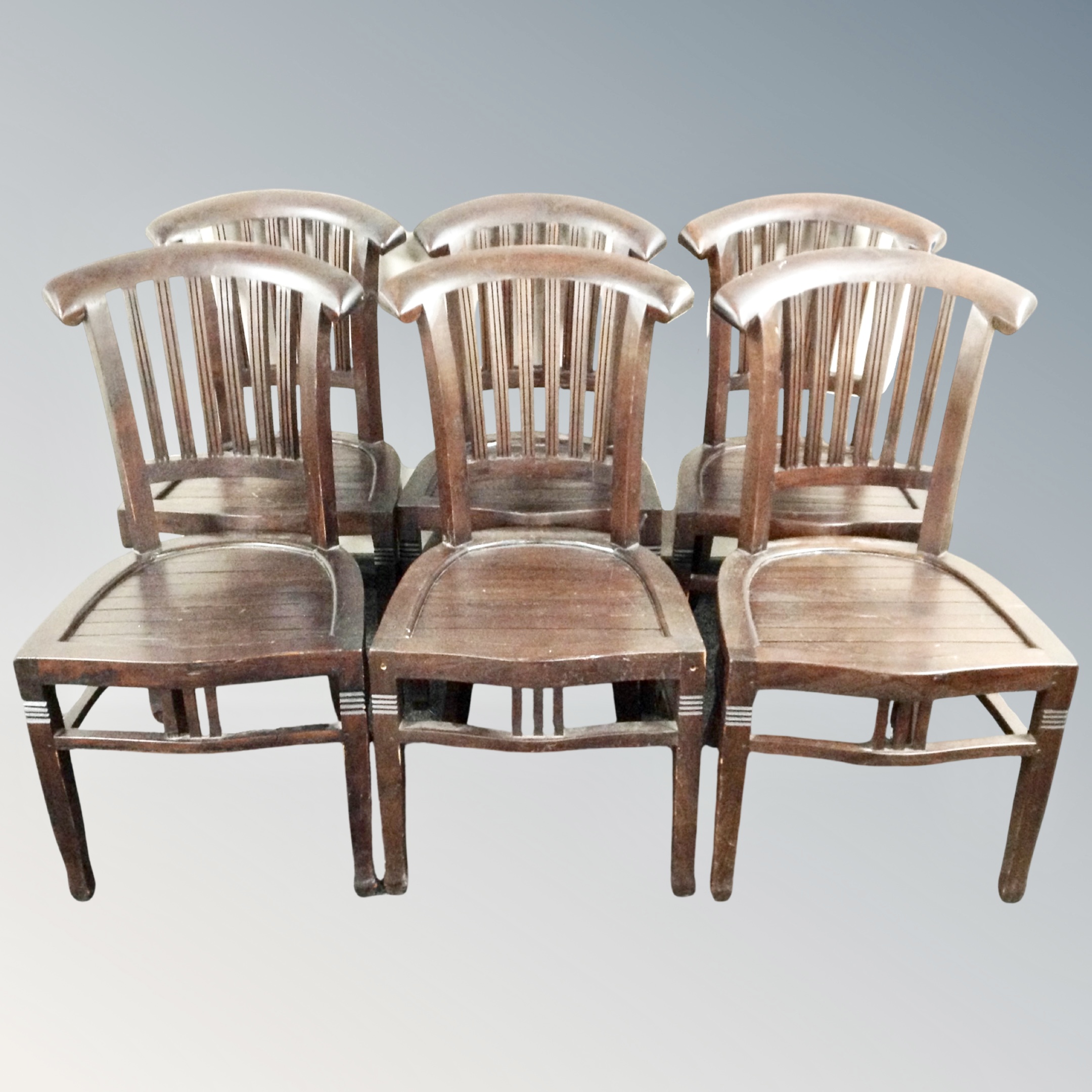 A set of six stained hardwood rail backed dining chairs