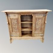 A continental oak double door sideboard with central shelves