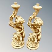 A pair of chalk gilt cherub lamp bases,