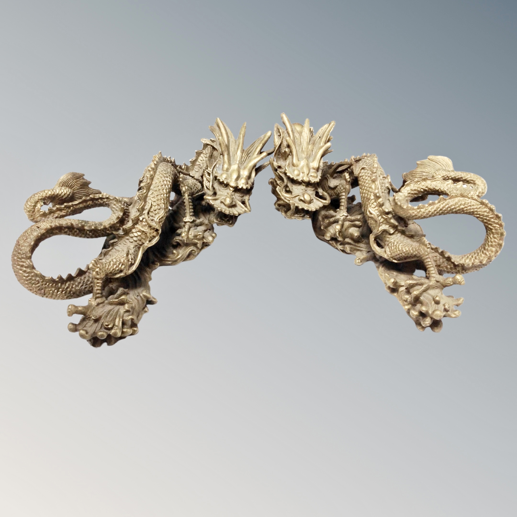 A pair of Chinese ornate brass dragon ornaments