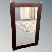 A mirror in oak frame with brass corner fixtures,