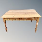 A pine farmhouse kitchen table fitted with two drawers