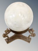 A Carrara marble 3'' sphere on brass stand decorated with sea horses