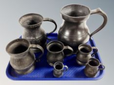 Seven graduated pewter tankards.