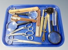 A tray containing letter knives, magnifying glasses, scissors.