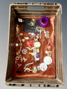 A basket of costume jewellery, pin badges, oversized watch,