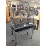 A metal bird cage on stand, 86cm wide by 54cm deep by 168cm high.