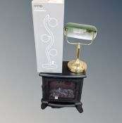 A heater in the form of a stove together with a contemporary bankers desk lamp and a further boxed