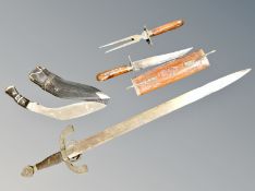 A Kukri knife in sheath, a sword and two further knives in wooden sheath.