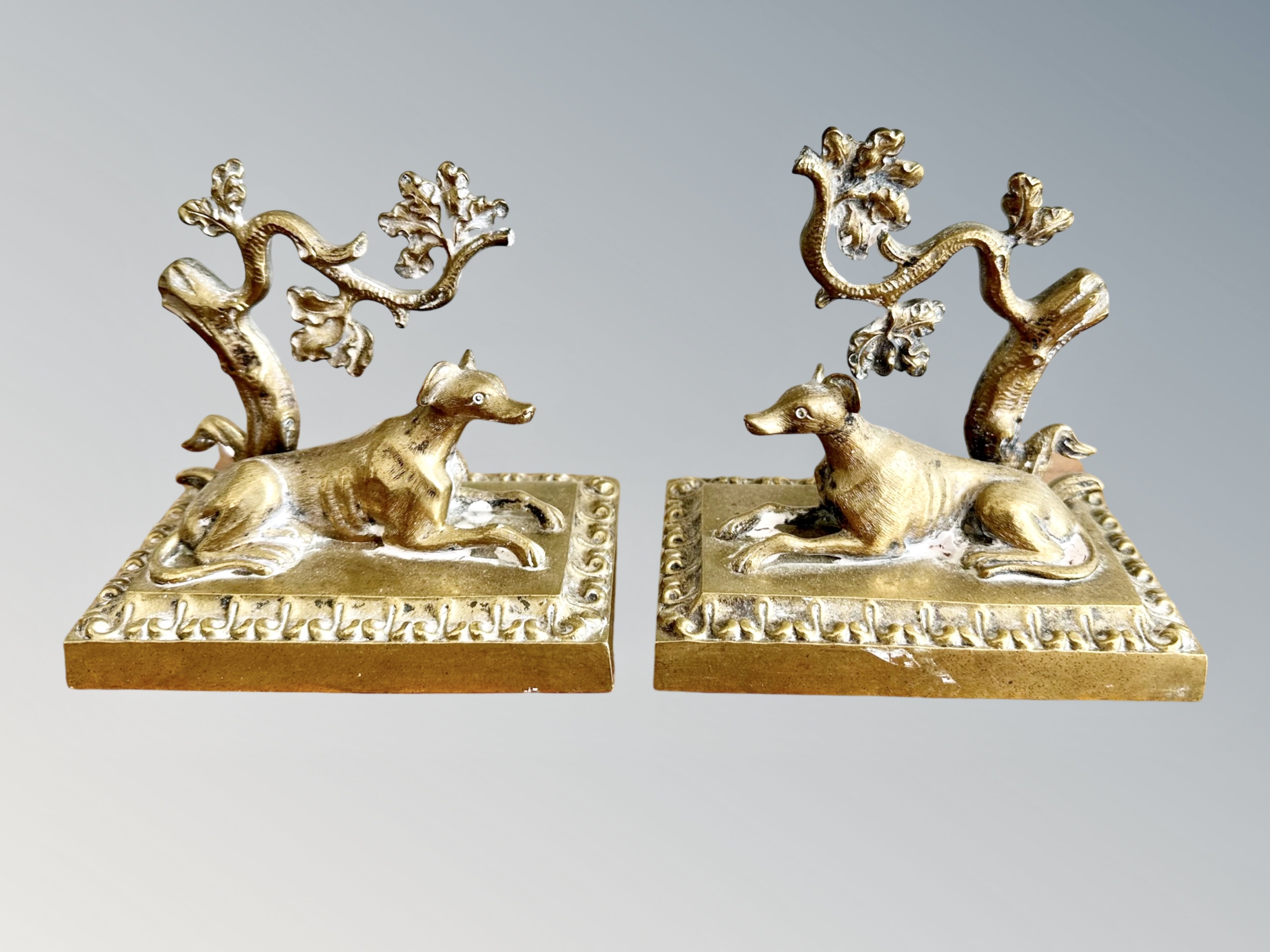 A pair of 19th century cast bronze statues of recumbent dogs,