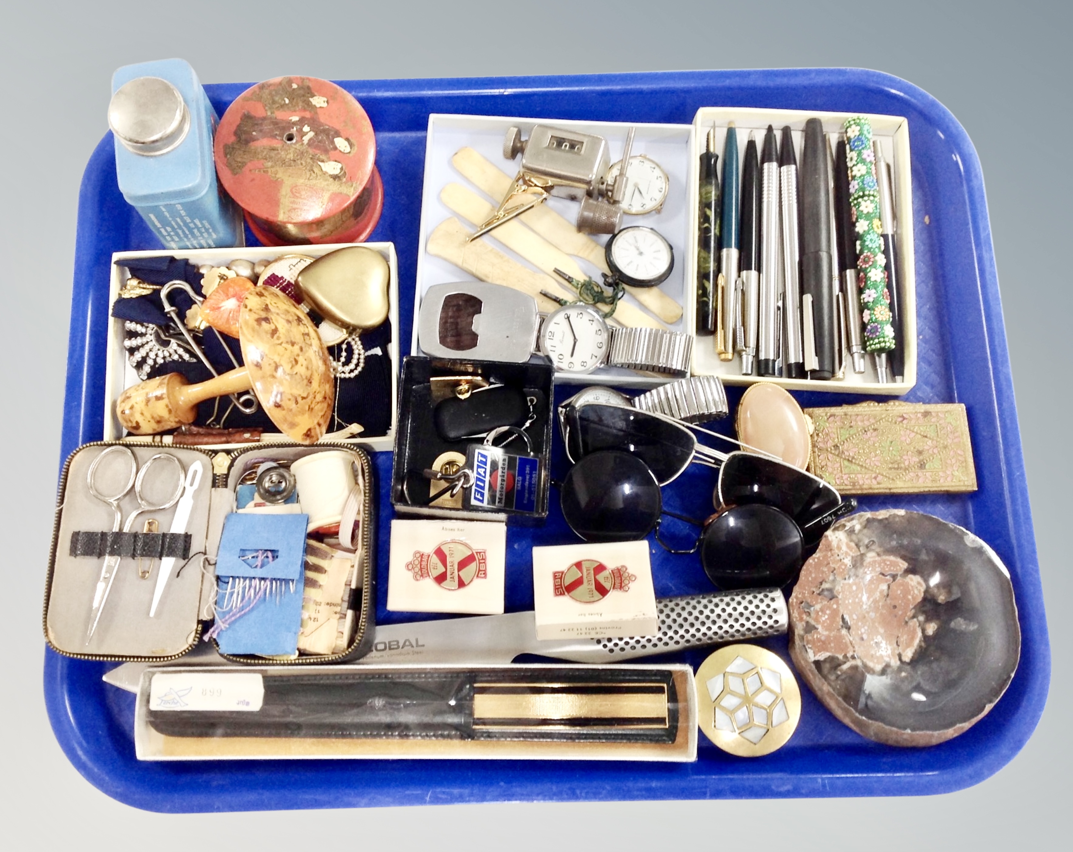 A tray containing sunglasses, costume jewelry, wrist and fob watches, ballpoint pens etc.