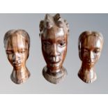 An African carved wooden bust, and a further similar pair,