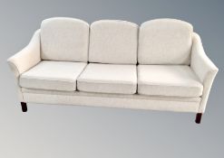 A Scandinavian three seater settee with matching wing backed armchair and further armchair in