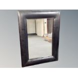 A black leather framed cushion mirror 91 cm x 122 cm