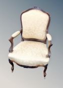 A Continental carved salon armchair in gold floral upholstery