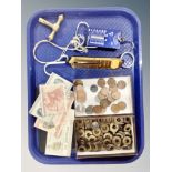 A tray containing pocket balance scales, foreign bank notes and coins.