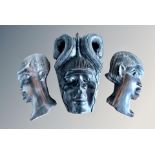 An African carved wooden mask wall plaque and two further similar,
