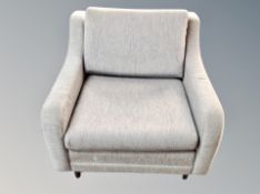 A Scandinavian low armchair on teak legs in grey upholstery
