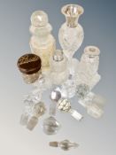 A tin of silver collared perfume bottles, quantity of stoppers, stud container,