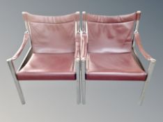 A pair of Scandinavian chrome framed armchairs with burgundy leather seats