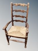 A child's ladder backed armchair with rattan seat