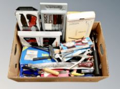 A box containing boxed and unboxed hand tools including screwdrivers, hammers, wire cutters.