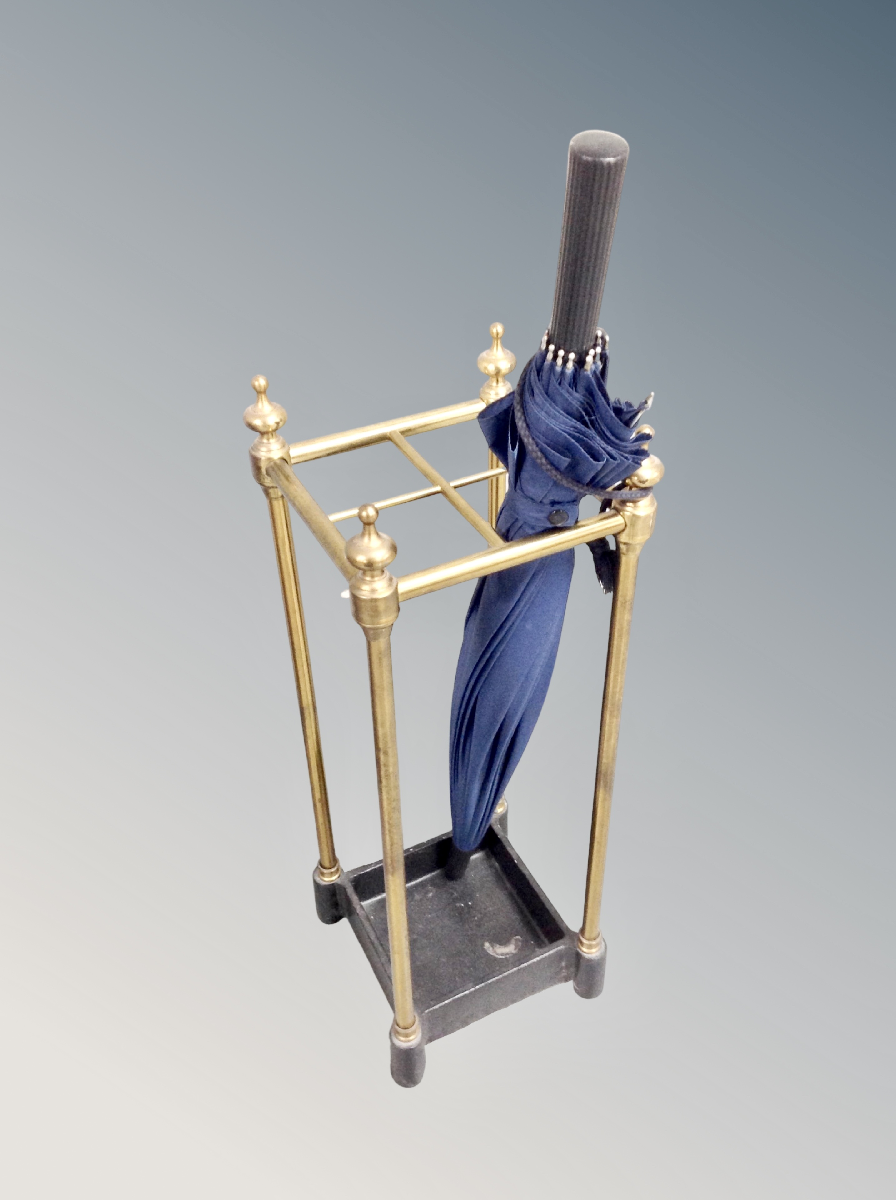 A cast iron and brass stick stand with umbrella