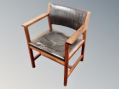 A Danish teak framed armchair in brown leather,